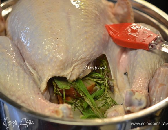 Добавить жидкость, яблоко и лук с палочками корицы в полость индюшки, розмарин и листья шалфея. Смазать с помощью кисточки растительным маслом кожицу индюшки и поставить в разогретую духовку. Ставим таймер на 30 мин. Затем снижаем температуру до 180°С и до готовности вашей индейки, на 6 кг на 3–3,5ч. Можно прикрыть фольгой или крышкой последний час.