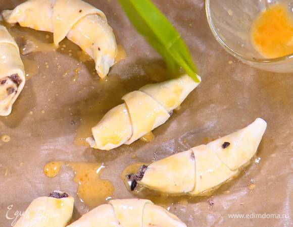 Яичный желток соединить с молоком, посолить, перемешать и кисточкой смазать круассаны.