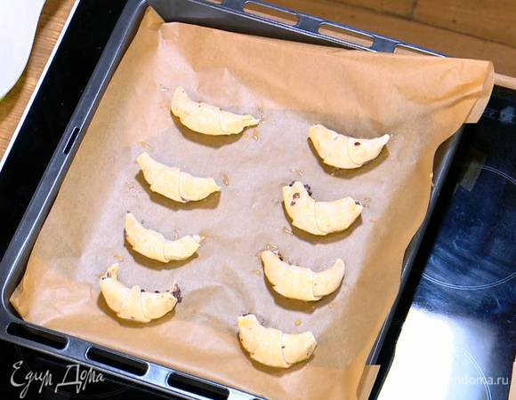 Противень выстелить бумагой для выпечки, выложить круассаны и выпекать в разогретой духовке 10 минут.