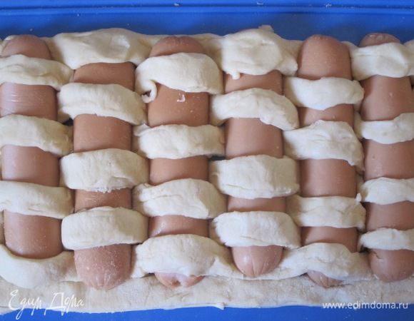 Сосиски переплести с полосками теста.