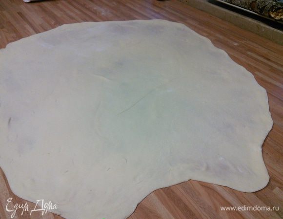 На посыпанной мукой поверхности раскатайте тесто в пласт 25 × 40 см, затем руками начинайте его растягивать до размера примерно 50 × 80 см. 