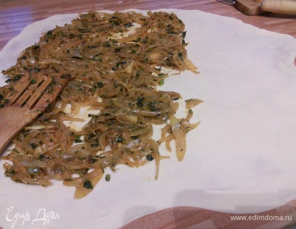 По 3/4 поверхности теста разложите лук и по узкой стороне заверните в рулет. Можно это сделать при помощи полотенца, но у меня всё получилось и без него, главное, чтобы поверхность была припылена мукой. 