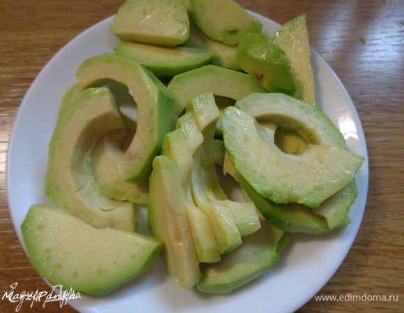 Авокадо очистить от кожуры, вынуть косточку и порезать дольками.