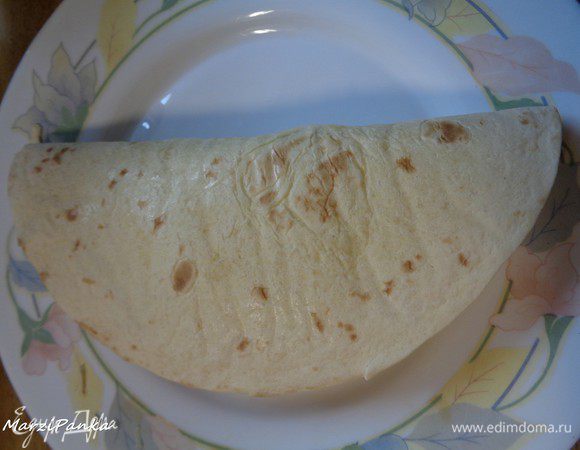Заворачиваем кесадилью так, чтобы половинка с соусом оказалась сверху.