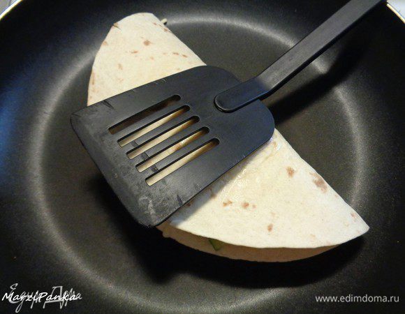 Кладем лепешку на сковородку также, чтобы слой с сыром оказался внизу, а половинка с соусом — сверху. 

Обжариваем кесадилью на сухой разогретой сковороде с двух сторон, прижимая лопаткой. Буквально по паре минут с каждой стороны. Как сыр подтаял — переворачиваем. Огонь делаем средний, чтобы ничего не пригорело.
