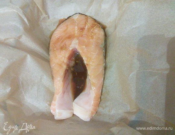 Форму для запекания выложить пергаментной бумаги с большим запасом. У меня были стойки лосося, но можно приготовить и филе. Выложить вымытый лосось. 