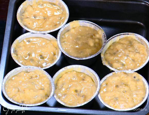 Формочки для маффинов смазать оставшимся сливочным маслом и разложить в них тесто.