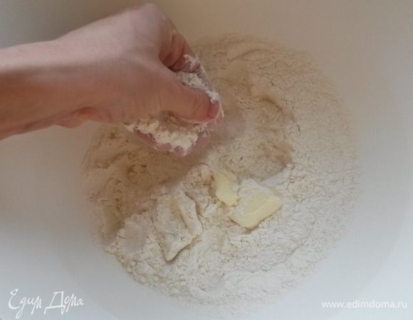 Добавляем кусочки холодного сливочного масла, растираем руками в мокрую крошку.