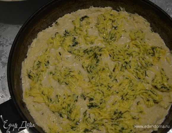 Картофель натираем на крупной терке и добавляем к заготовке. Солим и перчим.В форму для запекания диаметром 26 см выкладываем запеканку.
Сверху покрываем яично-сырно-укропной смесью.
