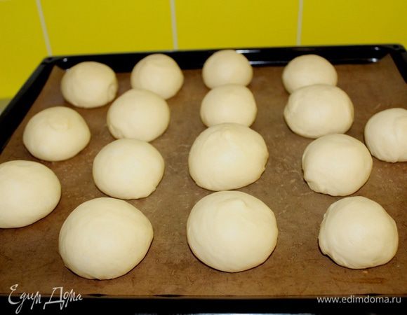 Разделить тесто на 15-16 булочек, выложить на противень, застеленный бумагой для выпечки, накрыть пленкой и убрать в холодильник или прохладное место на ночь (если вы печете булочки днем, то просто оставьте их минут на 40 при комнатной температуре, а через час отправьте в печь).