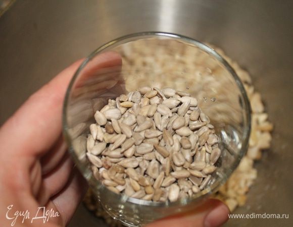 Семечки добавить к гречке (ее следует откинуть на сито), кешью слить и порубить. Также добавить в общую чашку. Всыпать кунжутные семечки.