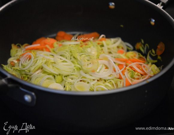 Разогреть духовку до 215°С.
Обжарить на оливковом масле тонко порезанный лук порей и морковь. Примерно 7 мин. Добавить чеснок мелко порезанный и готовить еще 1 минуту.