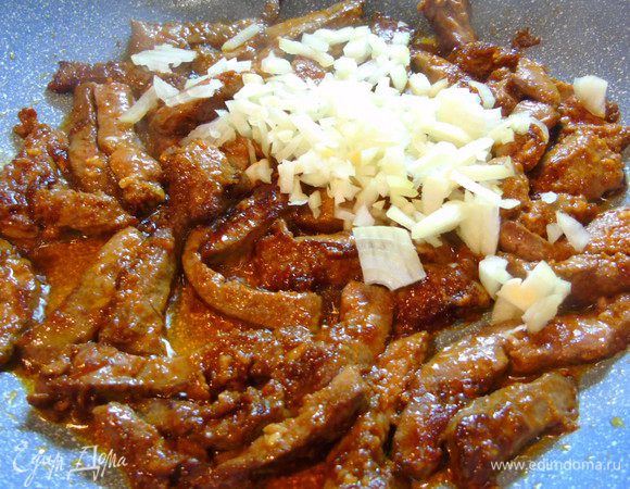 Добавьте мелко нарезанный лук и жарьте, постоянно помешивая, 1-2 минуты.