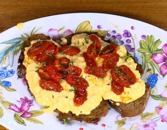 На обжаренный хлеб выложить яичную массу, сверху поместить запеченные помидоры и посыпать все листьями тимьяна.