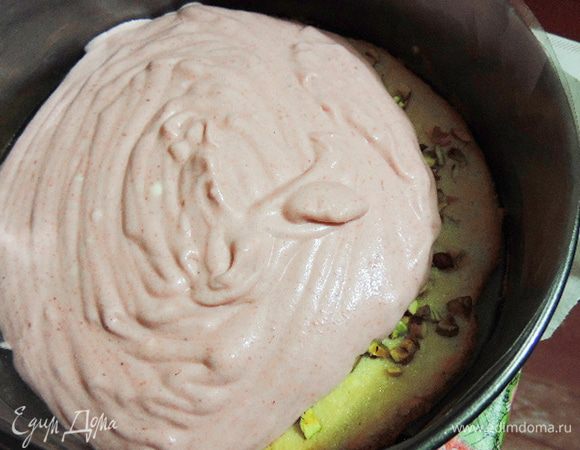 Теперь можно приступать к сборке торта.
Нам понадобиться разъемная форма диаметром 20 см. На дно кладем бумагу и бисквит фисташками вверх. Заполняем форму половиной малинового мусса.