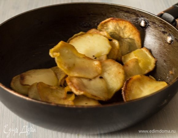 Картофель очистить, нарезать тонкими ломтиками и обжарить в растительном масле, обсушить на бумажном полотенце от лишнего жира.