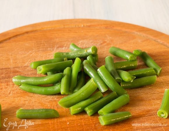 Стручковую фасоль разморозить и слегка бланшировать в горячей воде. Следите, чтобы она не потеряла свой цвет.