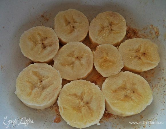 Дно керамической формы смазать маслом и посыпать сухарями, выложить банан кружочками.