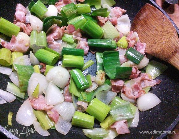 На той же сковороде разогреваем масло и обжариваем бекон и крупно порезанный лук-порей (его зелёную часть) и одну луковицу репчатую. 