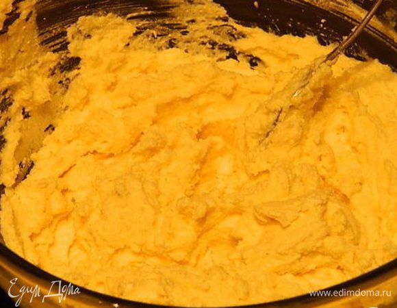 В миске взбить творог, мягкое сливочное масло, 100 г сахара, манную крупу, яйца и 1 ст. л. крахмала.