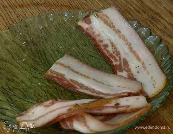 Оставшуюся грудинку нарезать полосками, выложить сверху на цыплят, затем посыпать тушки оставшимся виноградом.