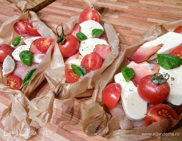 На ветчину выложить куриное филе, по 2-3 кружочка моцареллы, накрыть свисающими концами ветчины, разложить помидорки (если у вас обычные помидоры, то порежьте их на 4 части) и листья базилика. Сверху полить ложечкой хорошего оливкового масла. Ещё раз посолить и поперчить. Если у вас остались полосочки ветчины, разложите её кусочки дополнительно по свободным местам. 