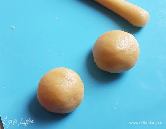 Разогреть духовку до 180°С. Противень застелить пергаментом. Отщипывать о теста кусочек, и скатывать из него шарик, затем из шарика колбаску.