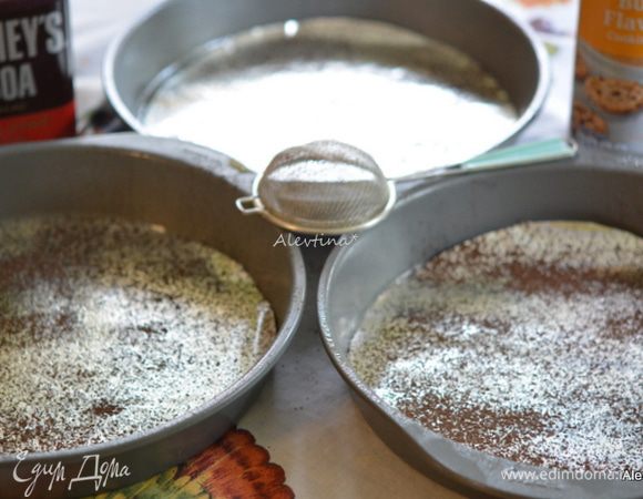 Разогреть духовку до 180°C .
Смазать маслом три одинаковые формы 23 см. Вырезать бумагу по форме и выложить на дно каждой формы, посыпать какао-порошком.