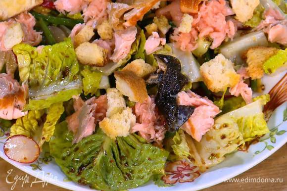 Салат переложить на большую тарелку, сверху разложить семгу, горячие крутоны и порезанную на кусочки рыбную кожу.
