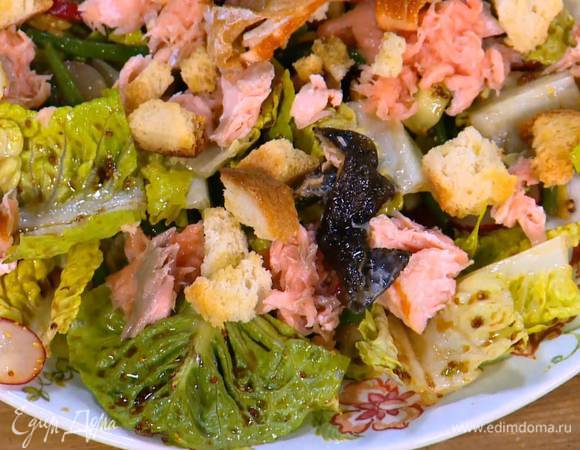 Салат переложить на большую тарелку, сверху разложить семгу, горячие крутоны и порезанную на кусочки рыбную кожу.