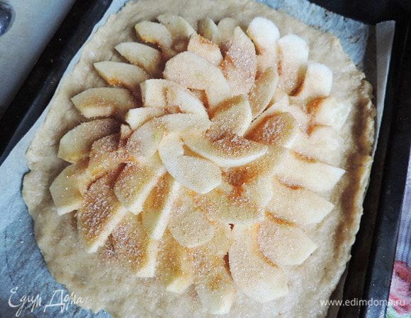 Яблоки среднего размера, очищаем от кожуры, удаляем сердцевину и нарезаем их дольками.
Тесто раскатываем в круг диаметром 30-35см. Раскладываем внахлест яблочные дольки, отступив от края 2-3см. Затем посыпаем яблоки сахаром, смешанным с корицей.