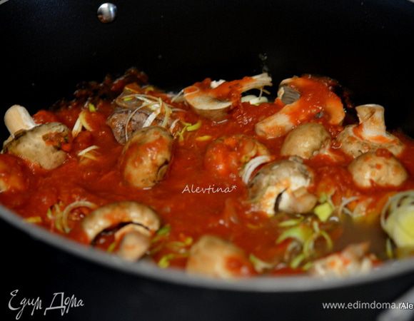 Обжарить отдельно грибы на оливковом масле 1 ст. л. Лук-порей очистить и порезать тонко. Добавить в общее блюдо грибы, лук-порей, чеснок дольку, томаты баночные порезанные, зелень порубленную, соль и черный перец. Закрыть крышкой жаровню и поставить в духовку на 2-3 часа.