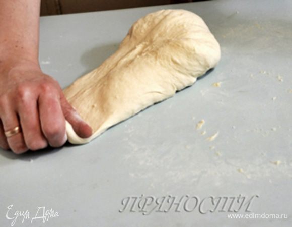 Когда вы этого добились, можно уже совсем слегка присыпать стол мукой и начать собирать тесто в шар. Берем тесто с одной стороны, немного оттягиваем его в сторону..