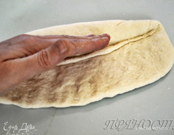 Затем берем одну из длинных сторон, заворачиваем ее к центру и хорошо запечатываем ладонью. 