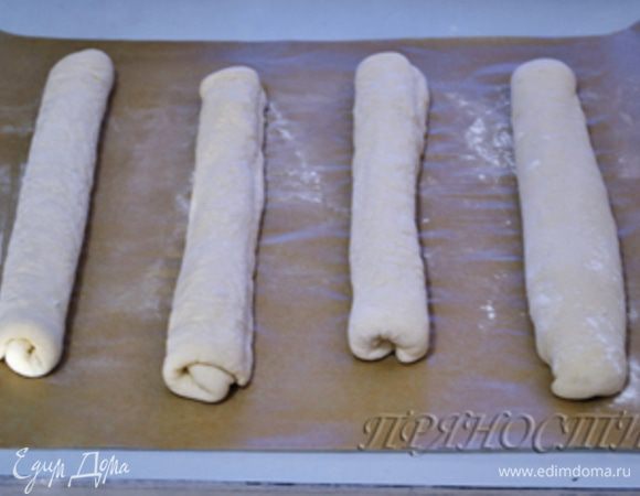 Немного прокатываем по рабочей поверхности, чтобы выровнять наш будущий хлеб, и далее выкладываем сразу на застеленный бумагой противень. Очень аккуратно растягиваем почти готовый багет по длине противня. Повторяем процедуру со всеми оставшимися шарами теста.