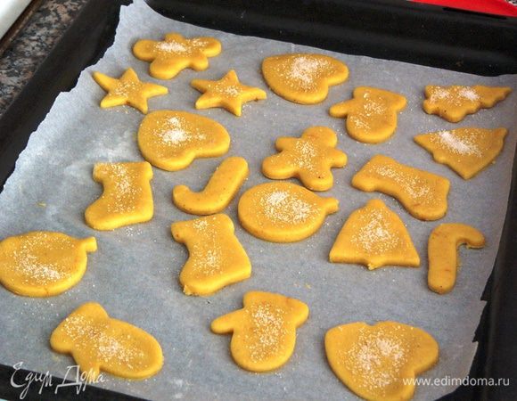 Бумагу с вырезанными печеньками поместить на противень. По желанию можно украсить печенья, посыпав сахаром или специальными украшениями для выпечки. 