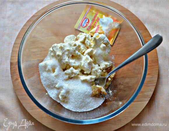 Тем временем очистите бананы и разомните с помощью вилки (бананы должны быть мягкими, спелыми). Добавьте творог, сахар, ванильный сахар и перемешайте. Добавьте муку и ещё перемешайте.