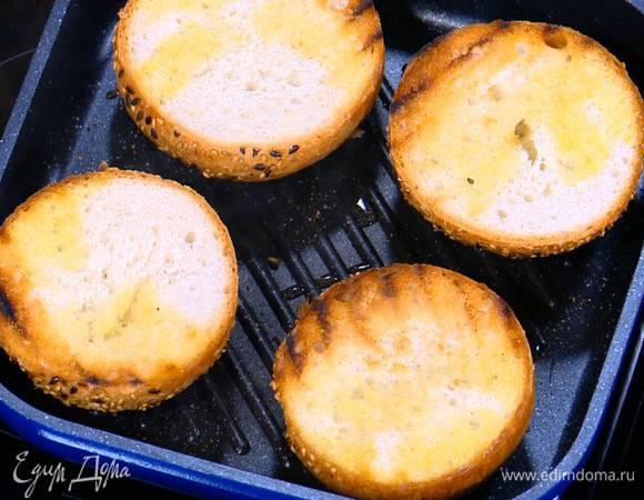 Разогреть в сковороде-гриль оставшееся оливковое масло, выложить булочки срезами вниз и обжаривать с двух сторон до появления золотистых полосок.