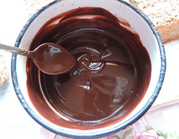 Для шоколадной прослойки (она же — ганаш) нужно нагреть сливки почти до кипения. Сливки можно взять 20%, можно более жирные — это неважно.
В горячие сливки высыпаем измельченный шоколад, даем минуту постоять и перемешиваем до полной однородности.