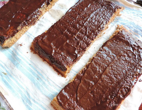 Каждый пласт бисквита смазываем шоколадной массой. Немного ждем, пока она впитается и загустеет.