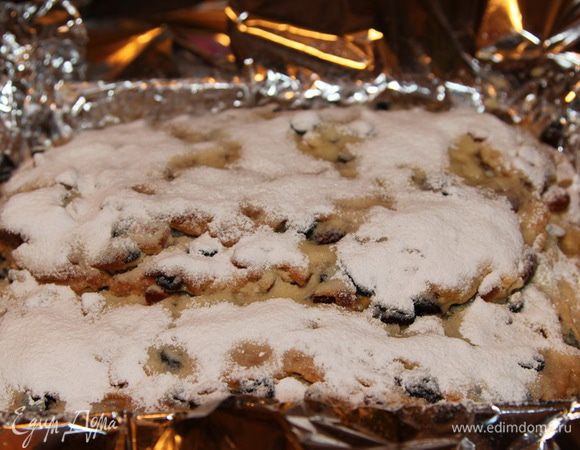 Помещаем туда горячий штоллен и поливаем его растопленным сливочным маслом (100 г) и щедро засыпаем сахарной пудрой.