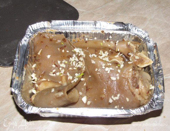 Взять подходящую по размеру форму и поместить туда одно ухо. Края подогнуть. Посыпать сверху мелко рубленным чесночком.