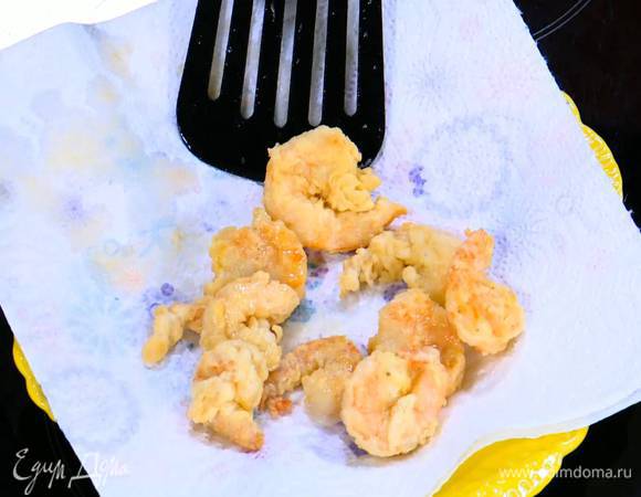 Креветки обвалять в муке и обжарить в раскаленном масле со всех сторон, а затем выложить на бумажное полотенце, чтобы удалить излишки жира.