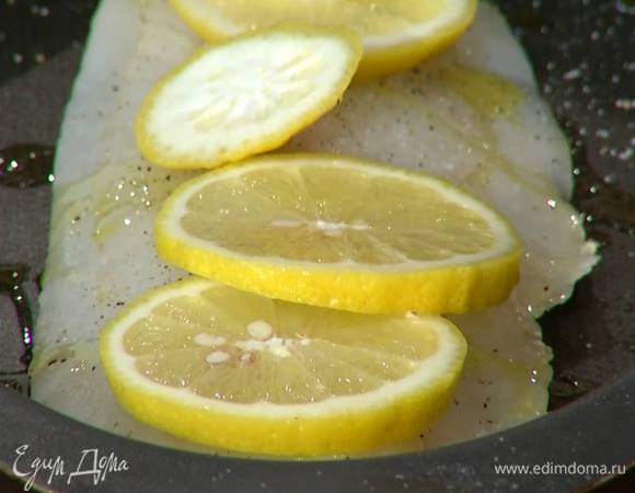 Половинку лимона нарезать кружками и поместить на рыбу. Отправить форму в разогретую духовку на 7 минут.