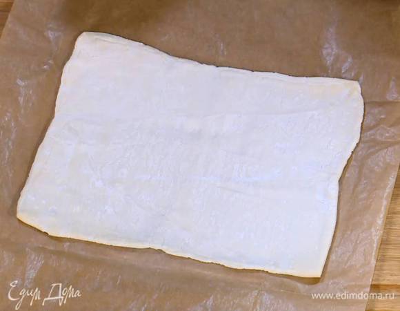Тесто предварительно разморозить, затем выложить на лист бумаги для выпечки, раскатать не слишком тонко и разрезать на 4 квадрата.