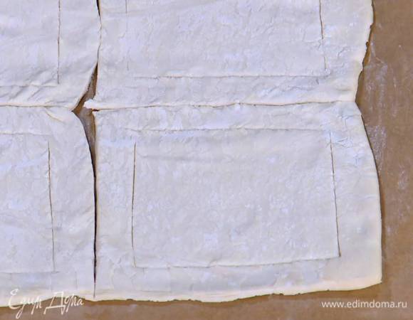 Отступая примерно на полтора сантиметра от краев и не прорезая тесто насквозь, ножом прочертить квадраты меньшей площади, чтобы получились бортики.
