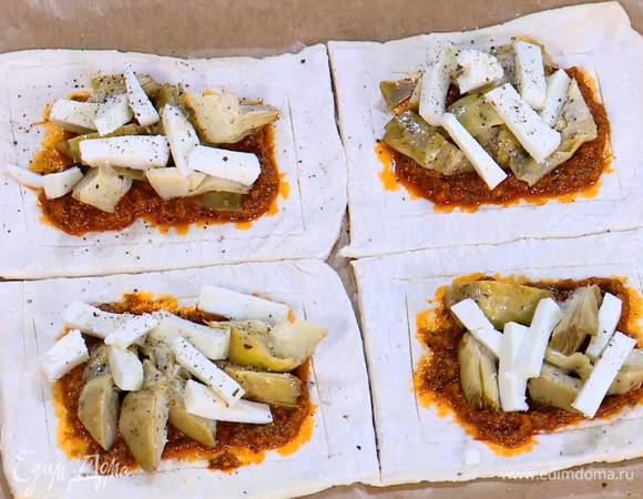 Центр каждого квадрата смазать соусом песто, выложить артишоки и козий сыр, все слегка посолить и поперчить.