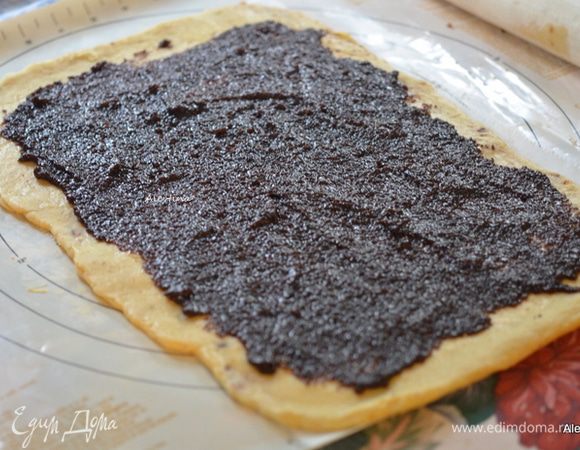 Намазать раскатанное тесто начинкой, оставляя с боков по сантиметру.
