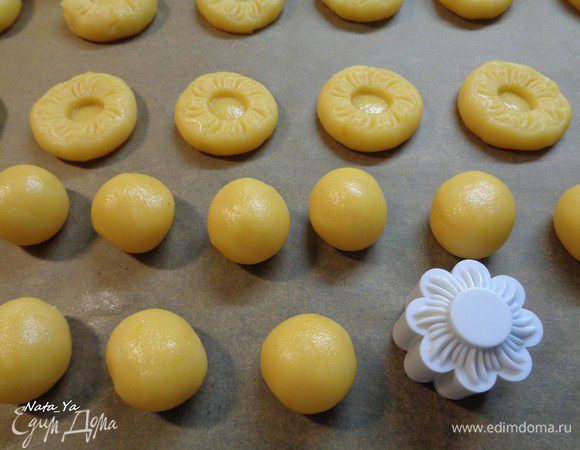 Затем сделать из теста шарики размером с грецкий орех, уложить на растоянии друг от друга на противень с бумагой для выпечки. 