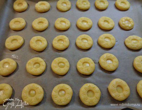 Я придала форму печенью с помощью специальной формочки. 

Но если ее нет, то можно просто приплюснуть каждый шарик ладошкой и с помощью, например, ручки от скалки, сделать в тесте углубления. В таком случае удобно уложить сверху пленку и делать углубления через пленку. Тогда углубления получаются ровными и тесто не клеится к дереву. Затем пленку аккуратно снять. 

Поставить печенье в холодильник на 1 час.
